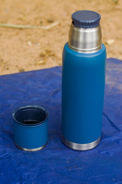 istock blue thermos flask with cup opened on the blue blanket on the sand 2165231566