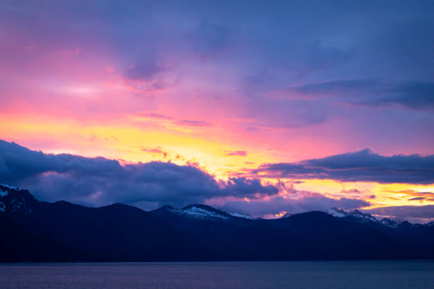Stunning colorful sunset over the mountains and lake shoreline in Alaska