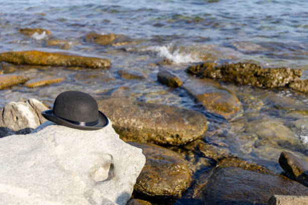 Bowler  cap on sea rock
