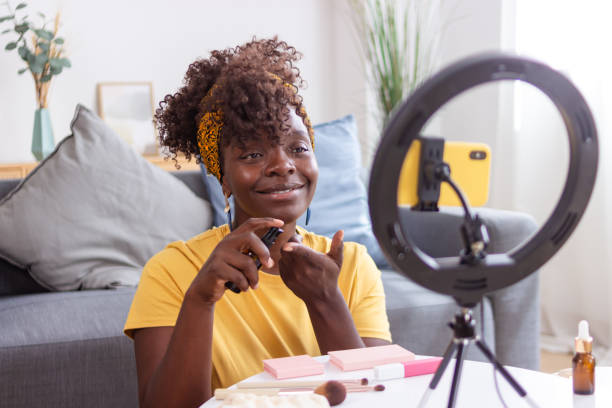 istock Young influencer applying beauty product while recording video using ring light 2165237527