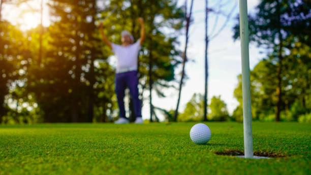 istock Golfers are putting golf in the evening golf course golf backglound. Golfer hitting golf ball. 2165245468