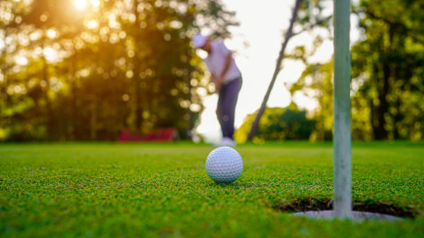 istock Golfers are putting golf in the evening golf course golf backglound. Golfer hitting golf ball. 2165245469