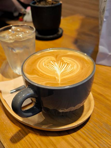 istock Hot latte coffee in ceramic cup on wooden table. Heart pattern latte art. Coffee menu. Cafe concept 2165247114