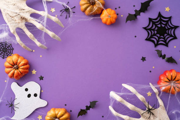 istock Spooky Halloween background featuring pumpkins, spider webs, bats, and a ghost cutout on a purple backdrop, evoking eerie holiday feelings 2165249997