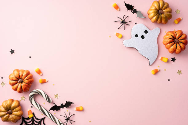 istock Festive Halloween background featuring pumpkins, ghost cutout, bats, spider, candy, and stars on a pink backdrop 2165250023