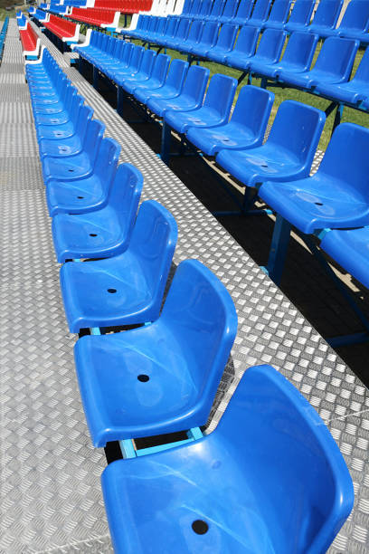 Empty seats in a small outdoor stadium, stands without people, nobody.