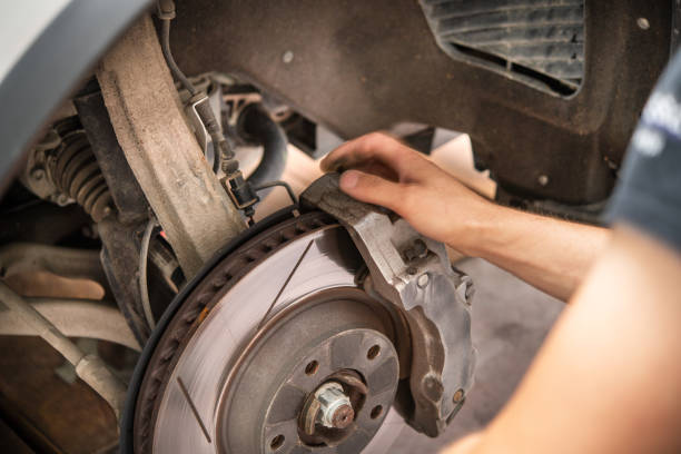 istock Expert Mechanic Performing Brake Maintenance on Vehicle in Automotive Workshop Setting 2165260425