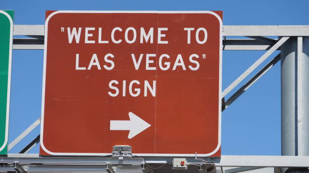 Las Vegas, August 23, 2024: The classic Welcome to Fabulous Las Vegas sign is shown on the median of Las Vegas Boulevard, framed by palm trees and a bright blue sky. Designed by YESCO in a googie, mid century style, the illuminated star and retro lettering greet drivers at the southern gateway to the Strip. The image conveys an instantly recognizable city icon, day time tourism, and the visual identity of Las Vegas. It fits travel guides, destination features, road trip stories, and articles about American roadside landmarks and neon design heritage.