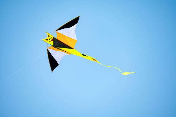 istock A bright kite flying in the blue sky, close-up 2165265735