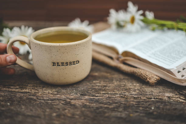 Cup with the inscription blessed and open Bible, Christian concept.