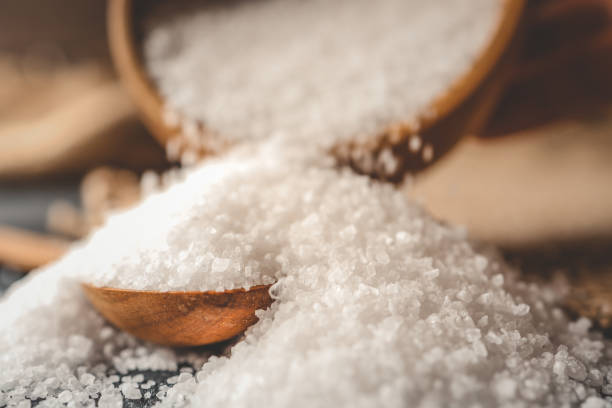 istock Pour salt into a wooden spoon, close-up 2165271217