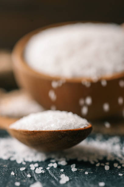 istock Pour salt into a wooden spoon, close-up 2165271220