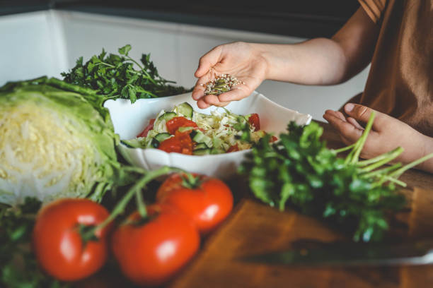istock Preparing vegetable salad, sprinkle flax and sesame seeds 2165271861