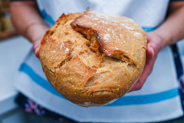 istock Woman holding fresh baked sourdough bread 2165276155