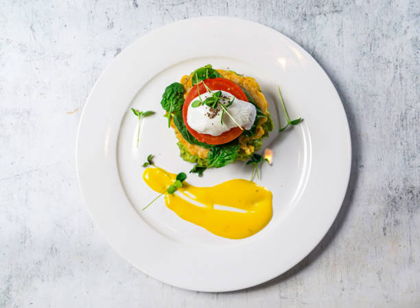 Corn Avocado Pancakes or Corn Fritters with cream and tomato served in plate isolated on background top view of italian food