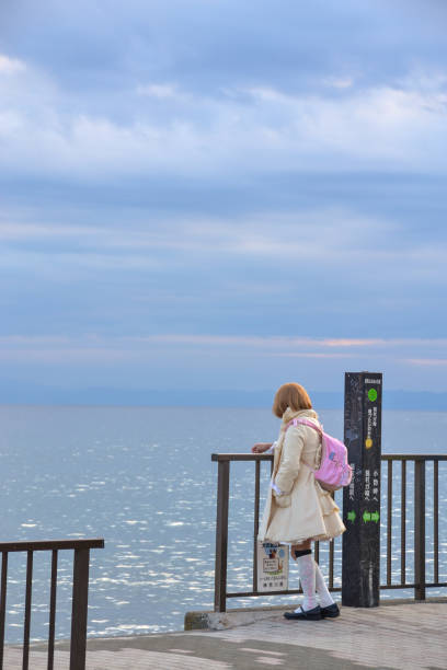 March 27th 2024. Girl wearing pastel-coloured clothes looking at the sea in Cape Inamuragasaki