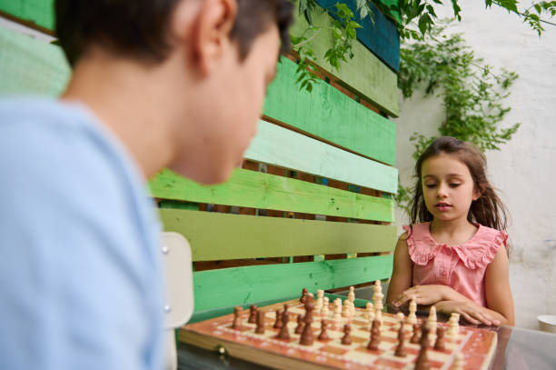 istock Children playing chess outdoors on a colorful wooden bench 2165276851
