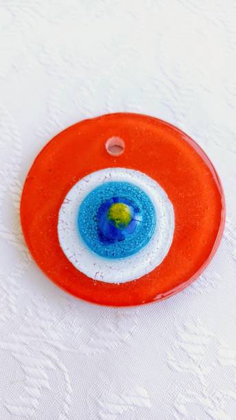 istock decorative orange glass evil eye bead on white background, ornament 2165280064