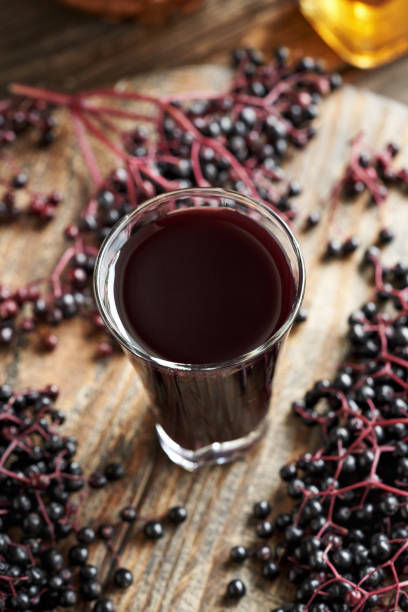 istock Black elderberry syrup in a glass cup with fresh berries 2165282799