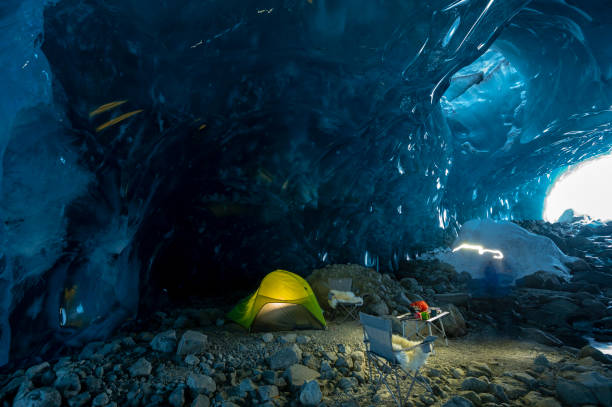 istock Illuminated tent and chairs in ice cave 2165283604