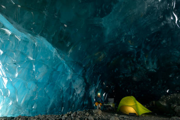 istock Explorer camps with tent in ice cave 2165283631