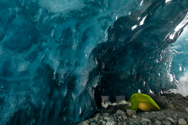 istock Illuminated tent and chairs in ice cave 2165283633