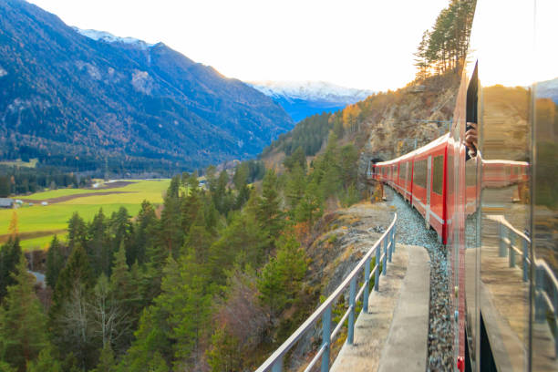 istock Red passenger train on Rhaetian railway in Canton Graubunden, Switzerland at autumn 2165284470