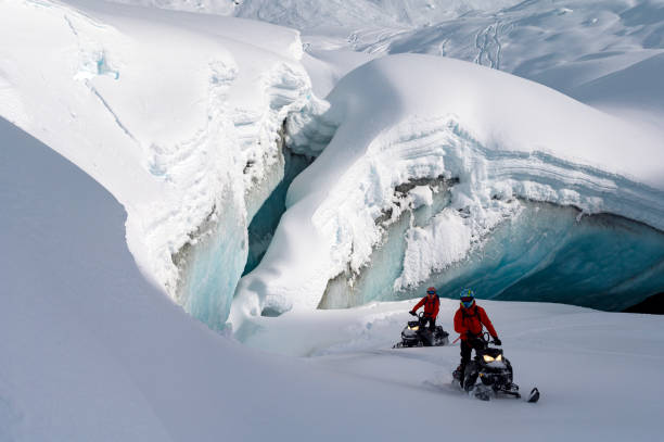 Backcountry snowmobiler rides across glacier