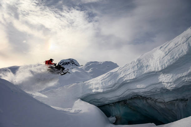 istock Backcountry snowmobiler jumps in front of ice cave 2165285896