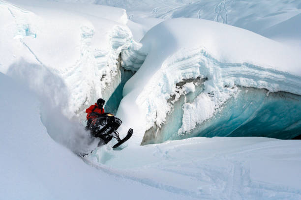 istock Backcountry snowmobiler jumps in front of ice cave 2165285927