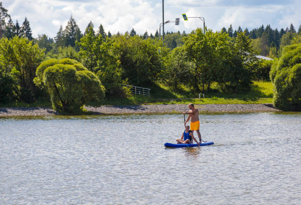 istock A father rides his son on a SUP board. 2165287366