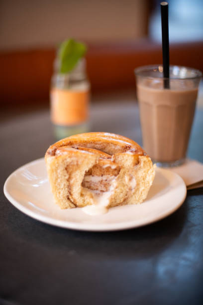 Cinnamon Roll and Iced Chai Latte on Black Marble Table