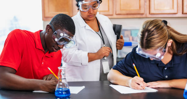 istock Teacher with students writing in chemistry lab 2165289419