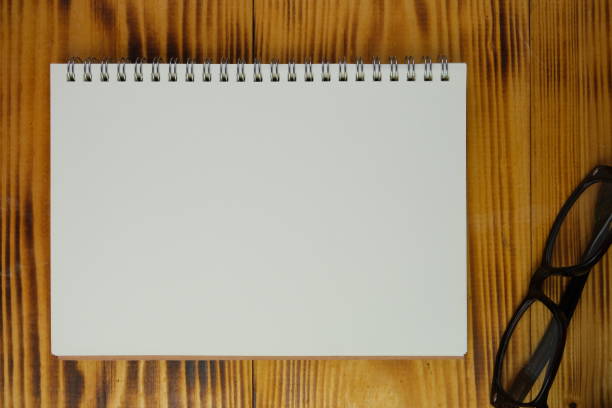 istock view of a workplace with a laptop and a notebook, on a wooden table. Education, business and office concept. 2165294708