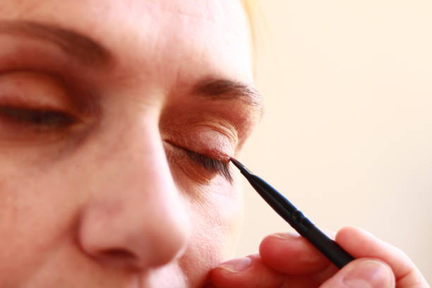 Woman Applying Eyeshadow on her Eyelid with a Makeup Brush