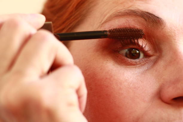 istock Woman Applying Mascara to her Eyelashes 2165295620