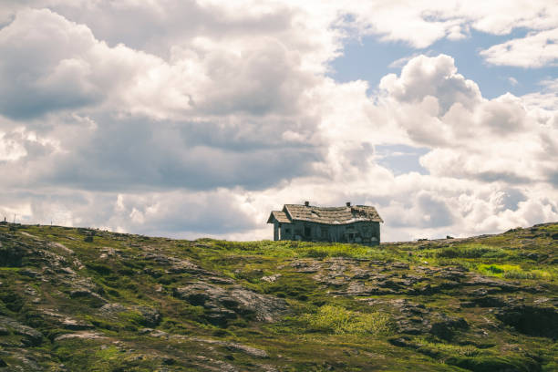 Solitary Abandoned House on a Rocky Hill Under Cloudy Sky