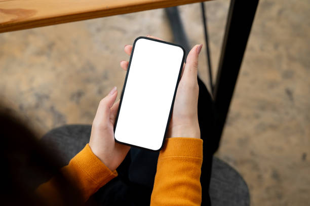 istock A woman sitting indoors and using her smartphone. a smartphone with a white-screen mockup. 2165302771