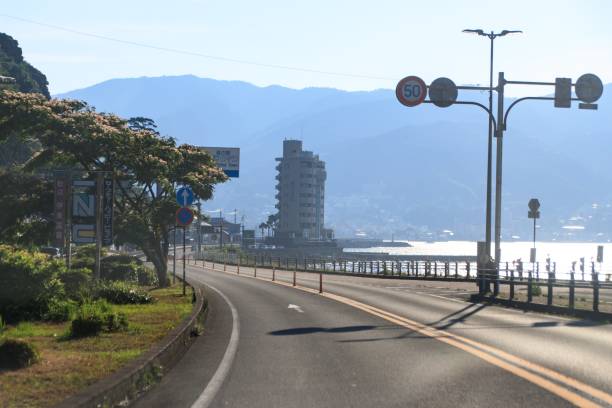 istock Curved Coastal Roadway Under Blue Sky With Clouds 2165303569