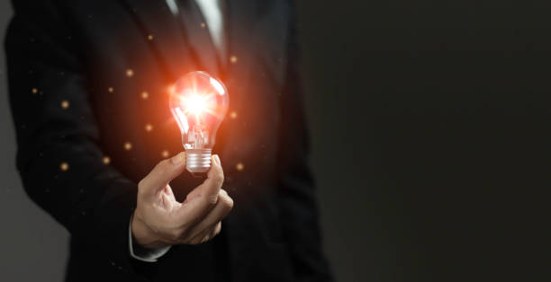 istock A man is holding a light bulb in his hand 2165304186