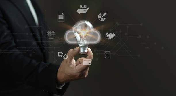 istock A man is holding a light bulb in his hand, surrounded by various icons 2165304188