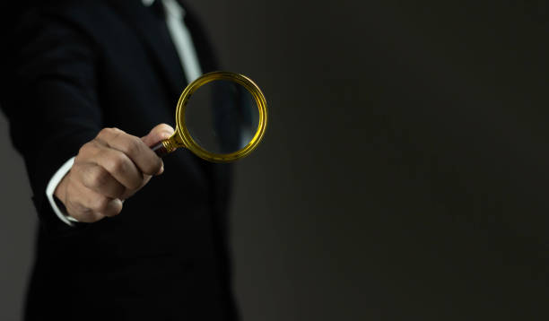 istock A man is holding a magnifying glass and looking at something 2165304190