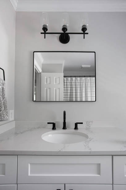 istock Stylish Bathroom With Square Mirror, Black Fixtures, And White Vanity 2165305520