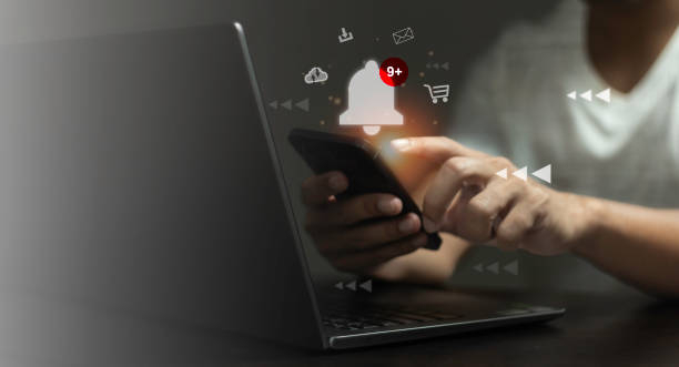 istock A person is using a laptop with a phone on it 2165305559