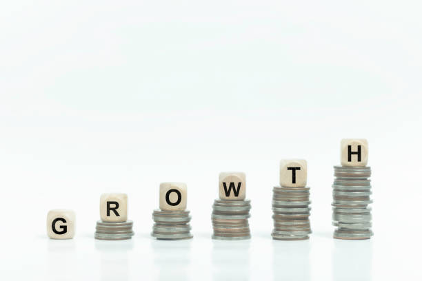 istock A stack of coins and a stack of wooden blocks with the word growth written on them. 2165305771
