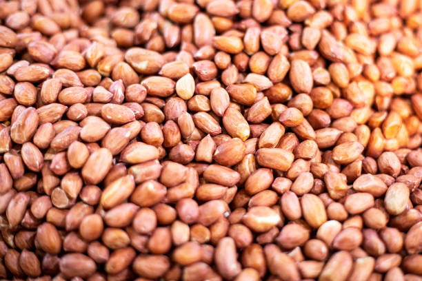 istock abstract background of peeled ripe peanuts 2165306107
