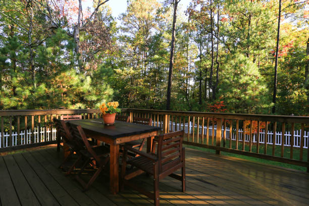 istock Wooden Deck With Outdoor Dining Table And Chairs Surrounded By Lush Trees 2165306149