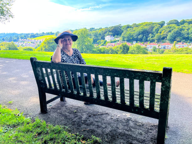 Senior Hispanic woman resting on park bench