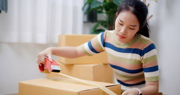 istock Young woman closes a box that has already been packed. 2165317065