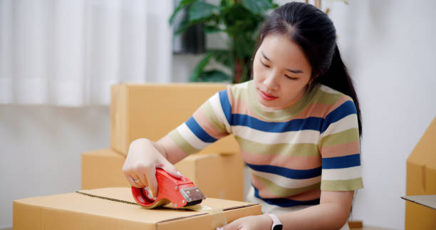 istock Young woman closes a box that has already been packed. 2165317067